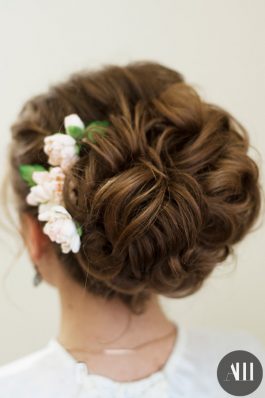 Воздушный пучок на свадьбу с цветами на средние волосы
